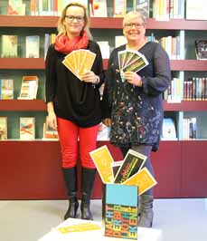 Bild: Anja Ricken (evo, li.) und Bibliotheksleiterin Diana Bengel mit den neuen Lesezeichen. (Foto: evo)